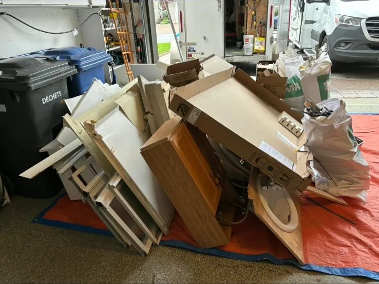 Vieilles armoires de cuisine et lavabo empilés dans un garage